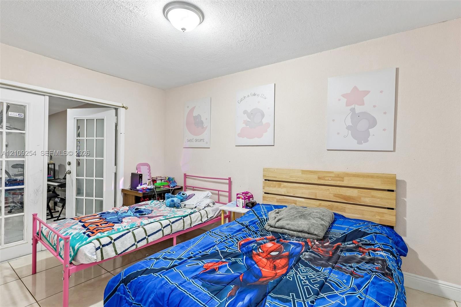 Room featuring ceramic tile flooring, neutral walls, and white French doors with glass panes