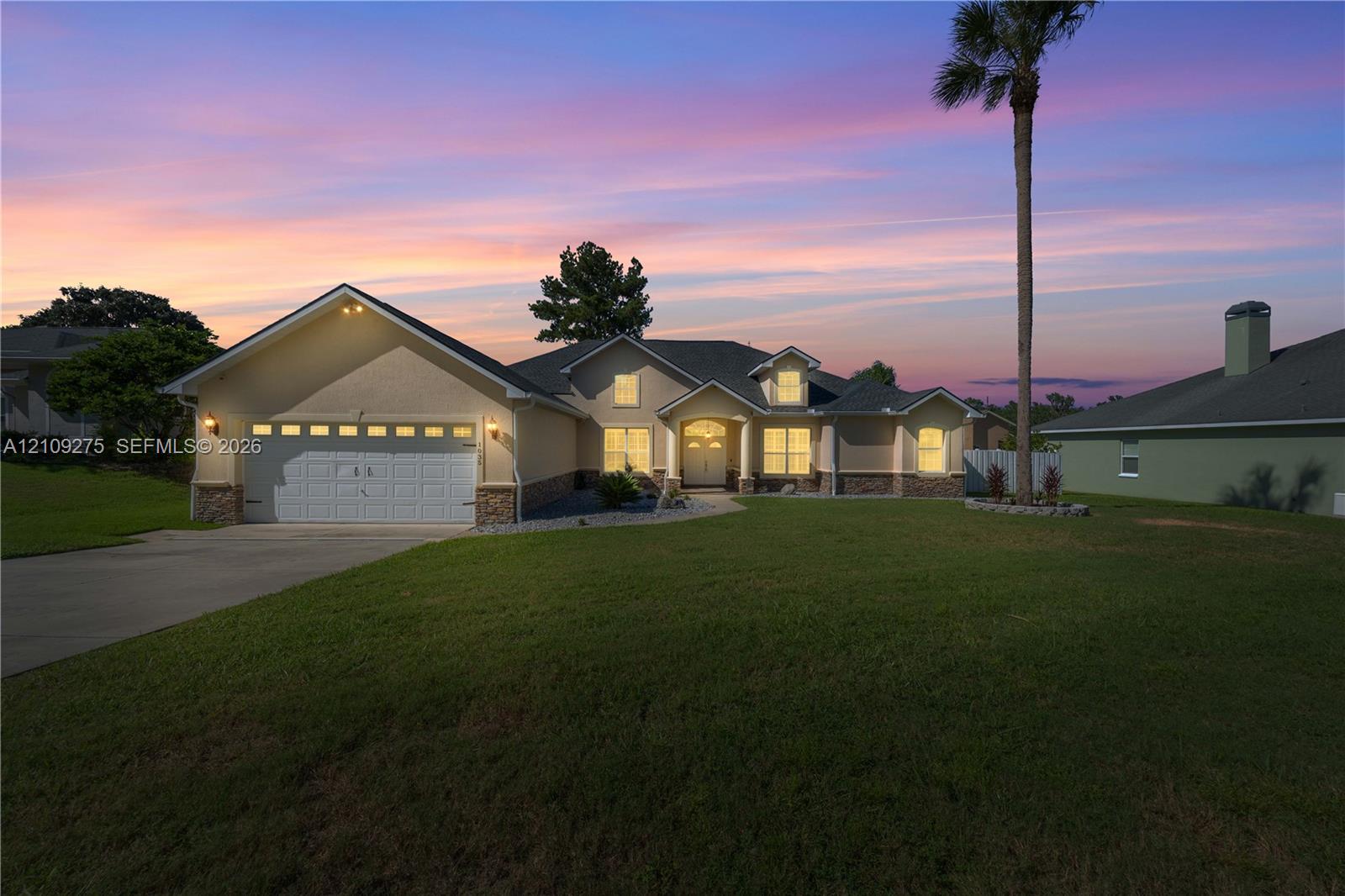 Single-story residence featuring a multi-gable roofline, stone veneer accents, an attached two-car garage, and a concrete driveway