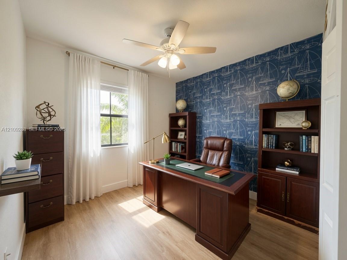 Interior space featuring wood-finish flooring, a ceiling fan with integrated lighting, and a window with a curtain rod