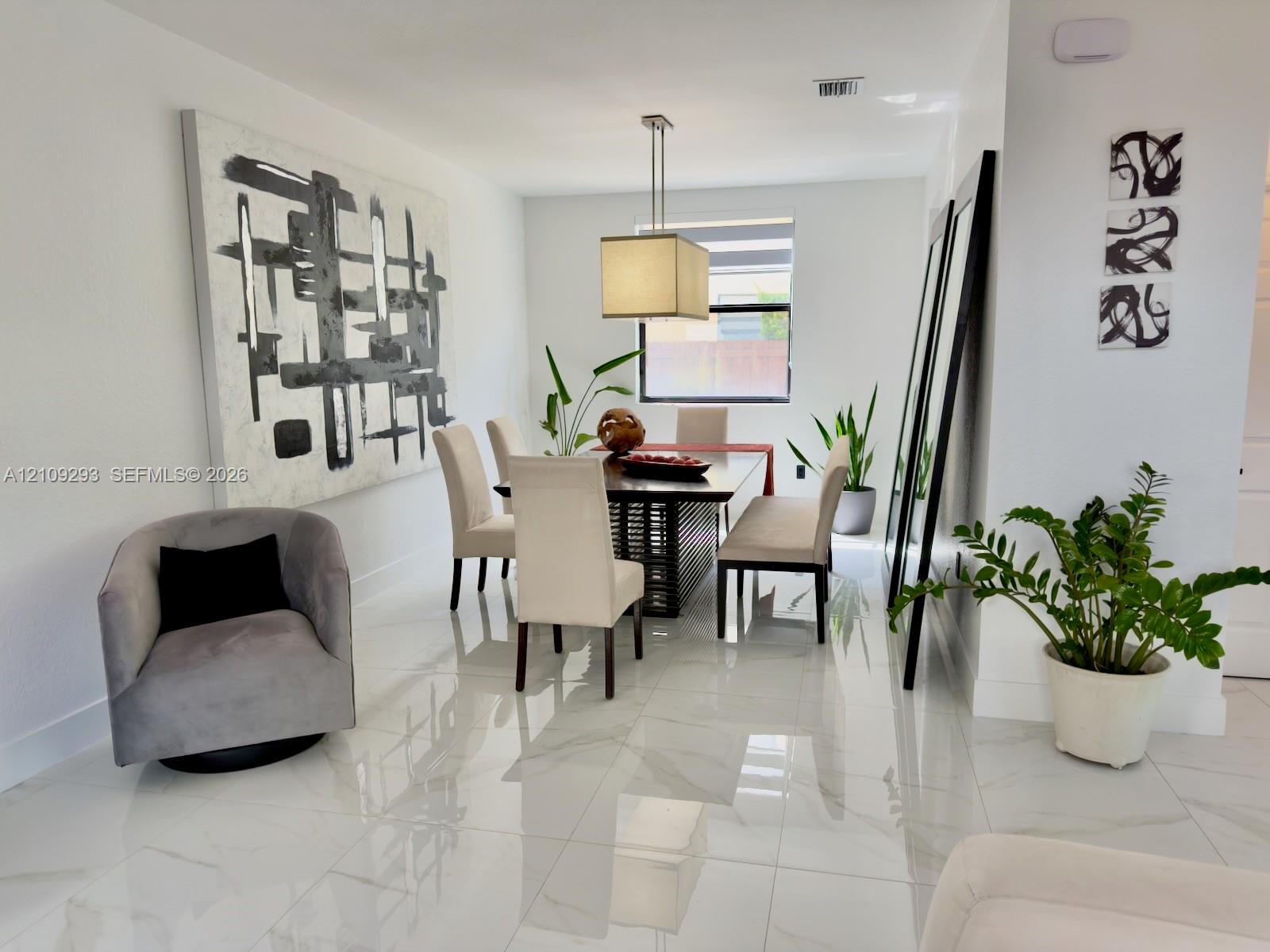Neutral-toned interior space featuring polished large-format tile flooring and a suspended rectangular pendant light fixture