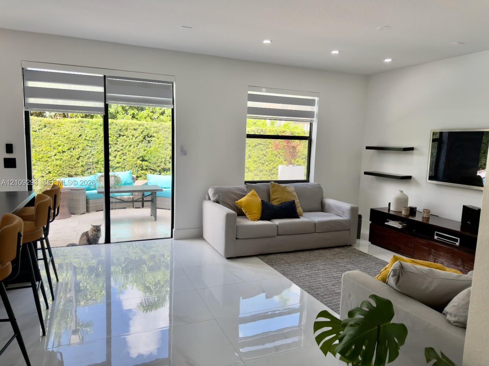 High-gloss tile flooring, floor-to-ceiling sliding glass doors, recessed lighting, and built-in wall-mounted shelving