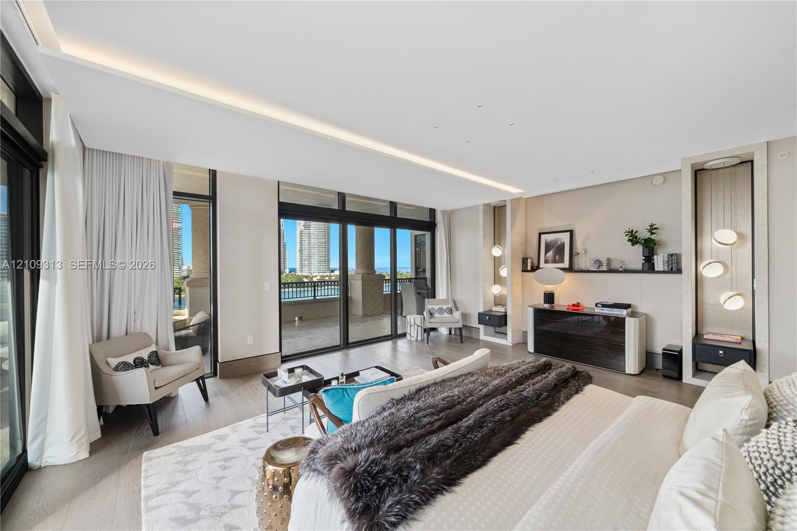 Floor-to-ceiling sliding glass doors, built-in recessed shelving with integrated accent lighting, light-toned wood-finish flooring, and a covered balcony