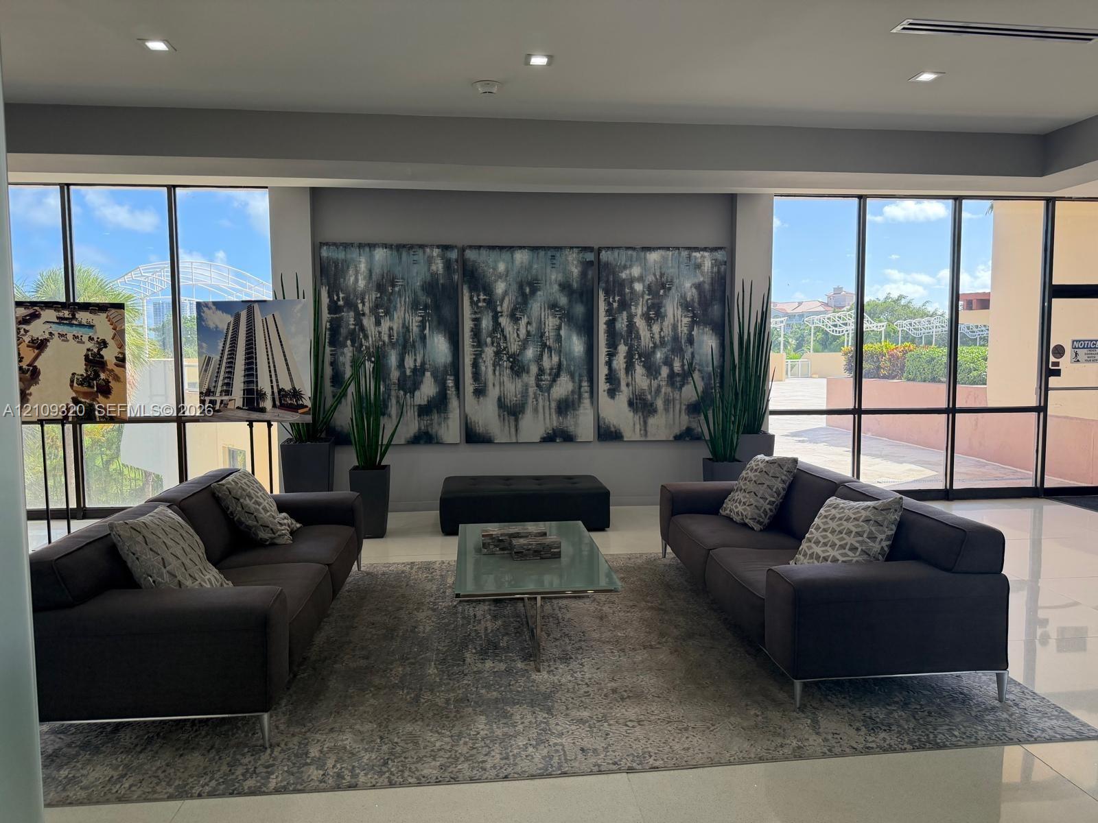 Elevator lobby featuring stone-clad wall accents, stainless steel elevator doors, recessed lighting, and polished flooring