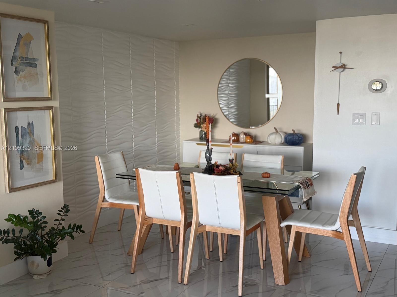 Textured three-dimensional accent wall, large-format polished tile flooring, and circular wall mirror