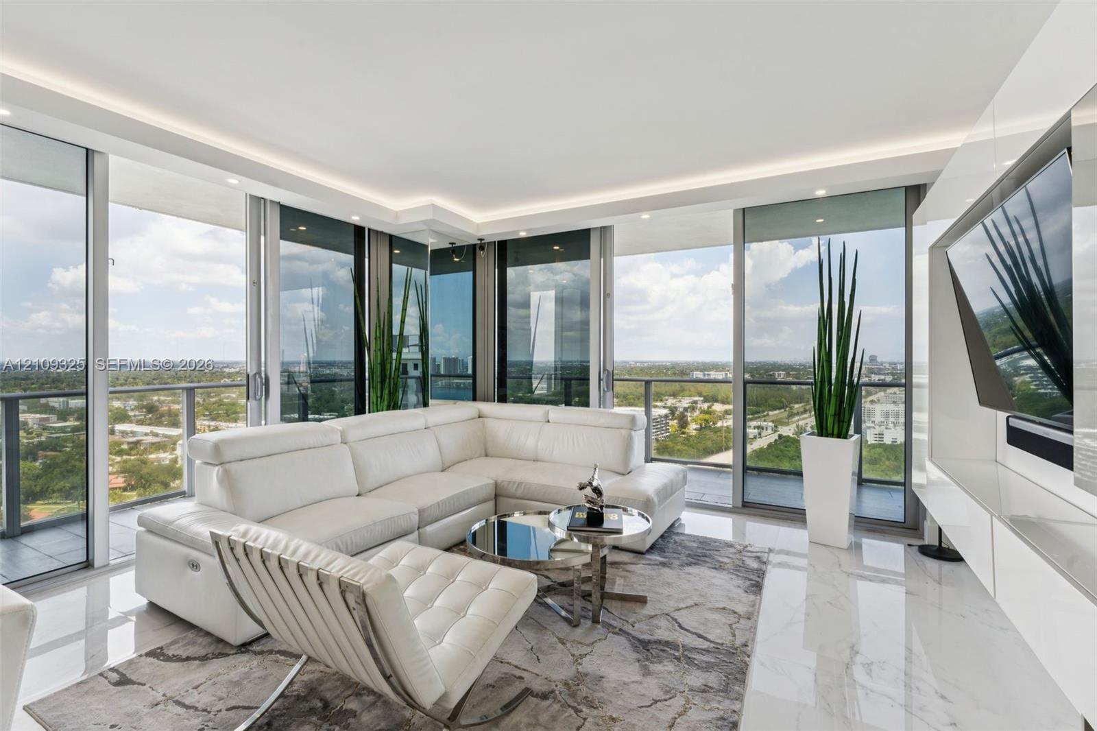 Floor-to-ceiling glass walls, polished stone flooring, recessed ceiling lighting, and built-in high-gloss wall cabinetry