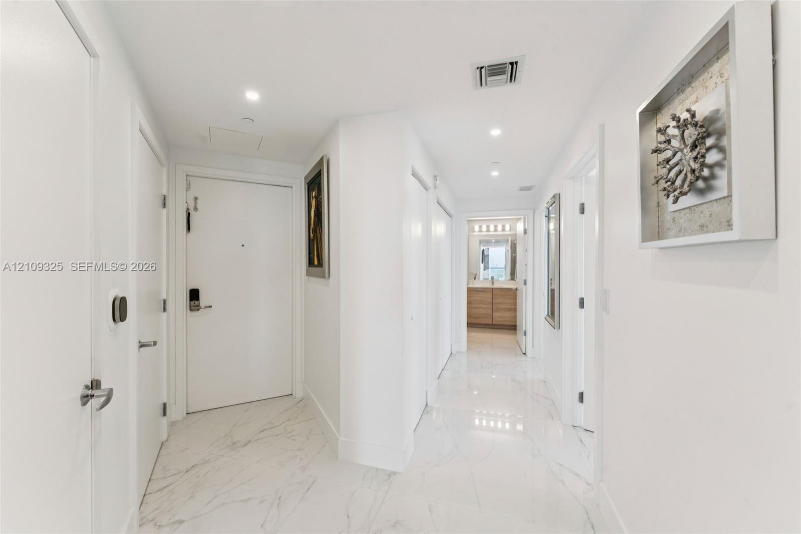 Entryway featuring polished stone-finish flooring, recessed lighting, and crisp white interior doors