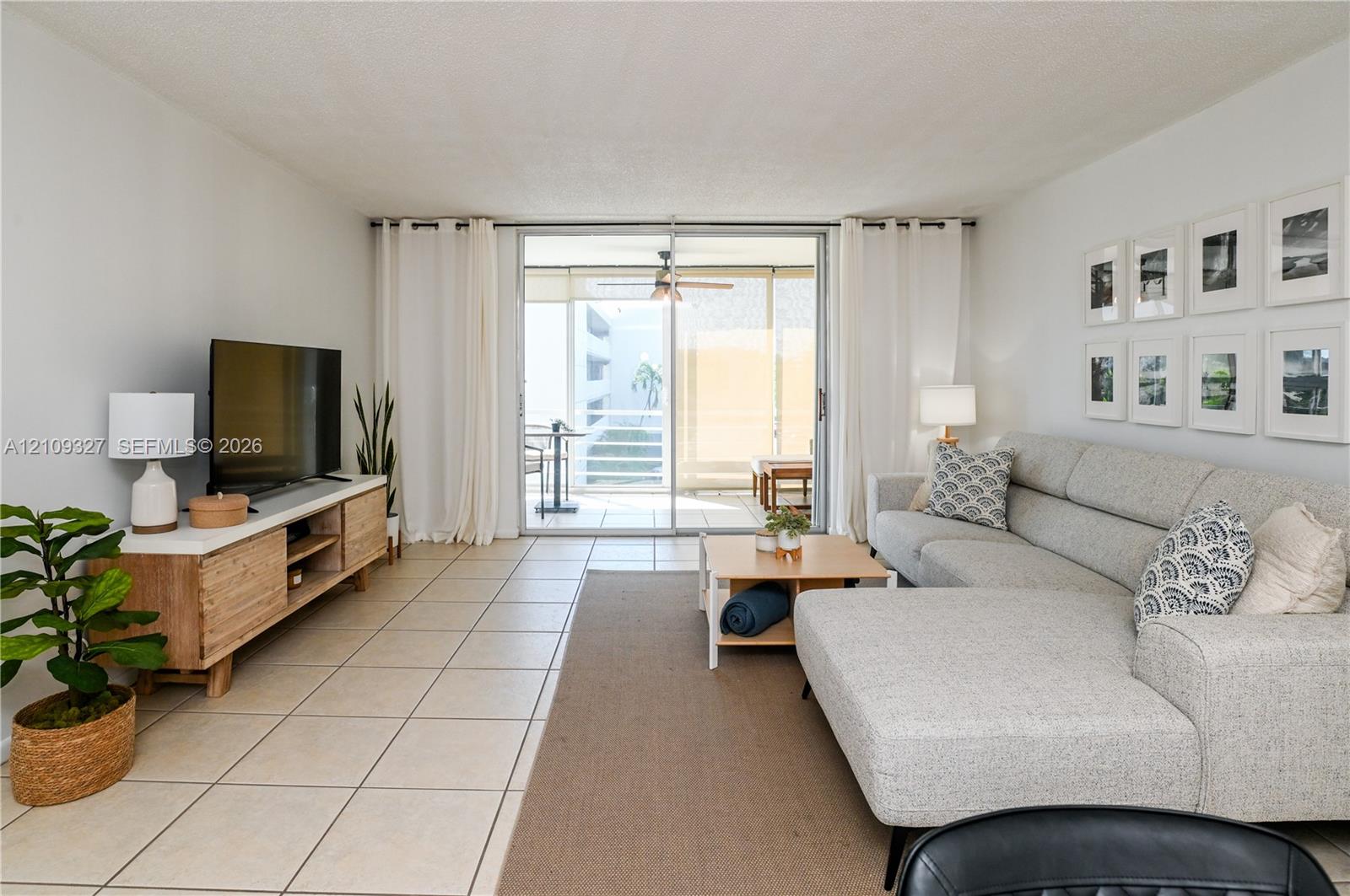 Living area featuring large format tile flooring and sliding glass doors to balcony
