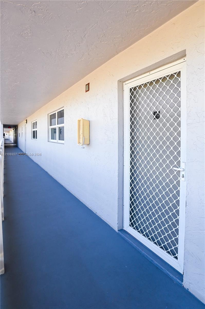 Exterior entry featuring a white metal security storm door