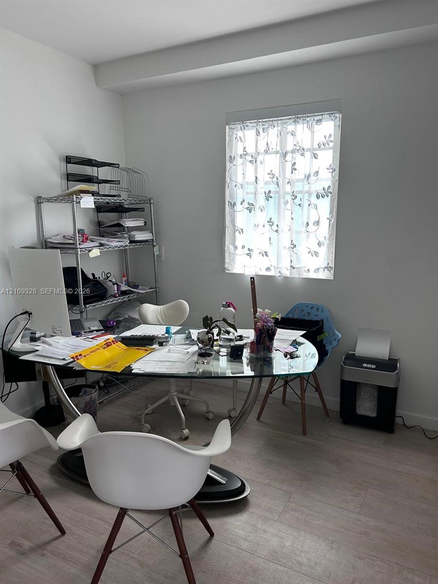 Neutral-toned room featuring wood-finish flooring and a window providing natural light