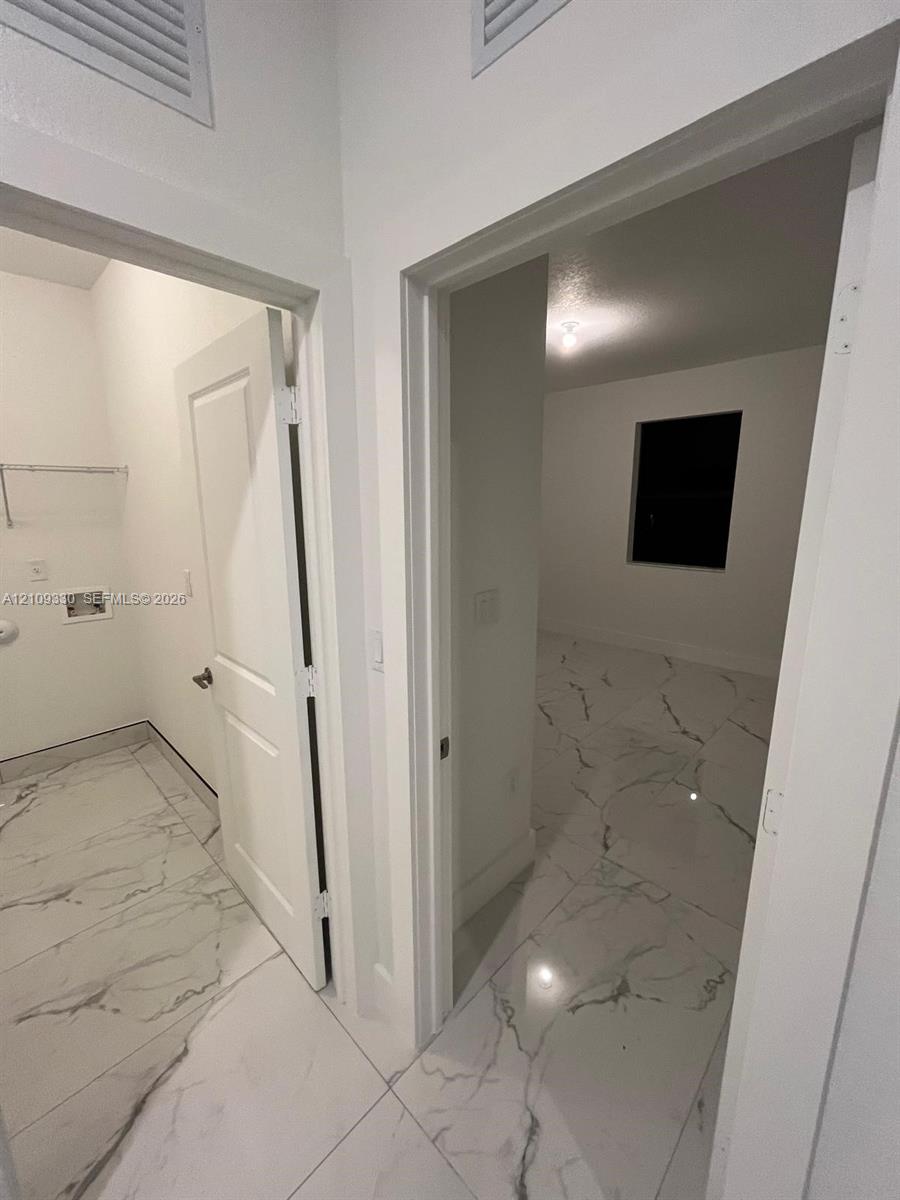 Large-format stone-look tile flooring, solid-core interior doors, and dedicated laundry utility connections