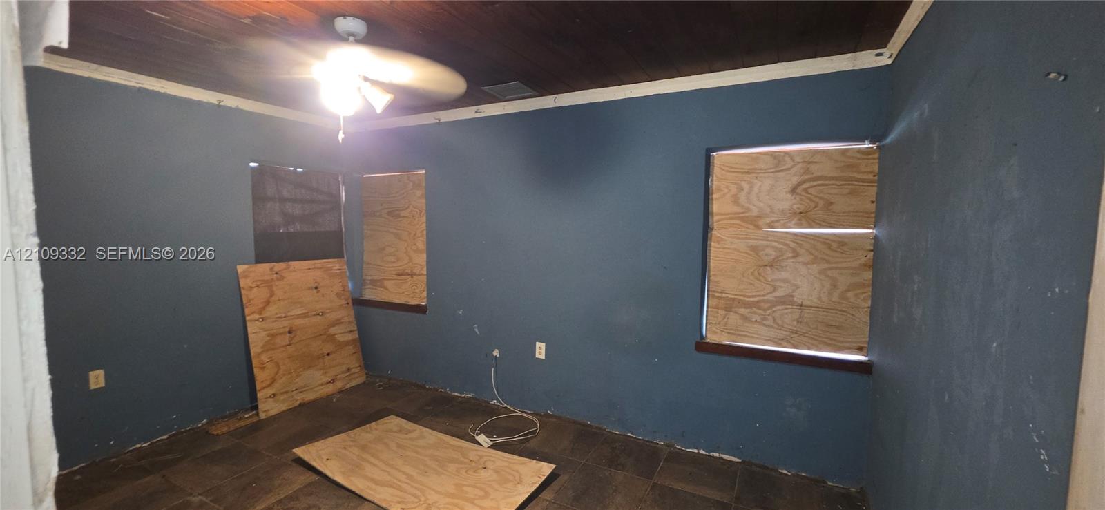 Interior room featuring a wood-plank ceiling, ceiling fan, and large-format floor tiling