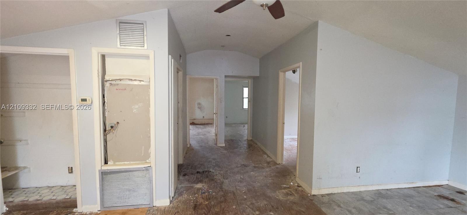 Vaulted ceiling featuring a central ceiling fan