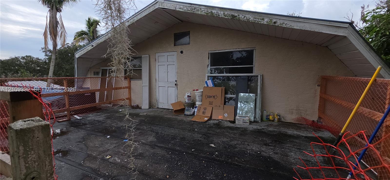 Stucco exterior featuring a pitched roofline, sliding glass window, and a multi-panel door