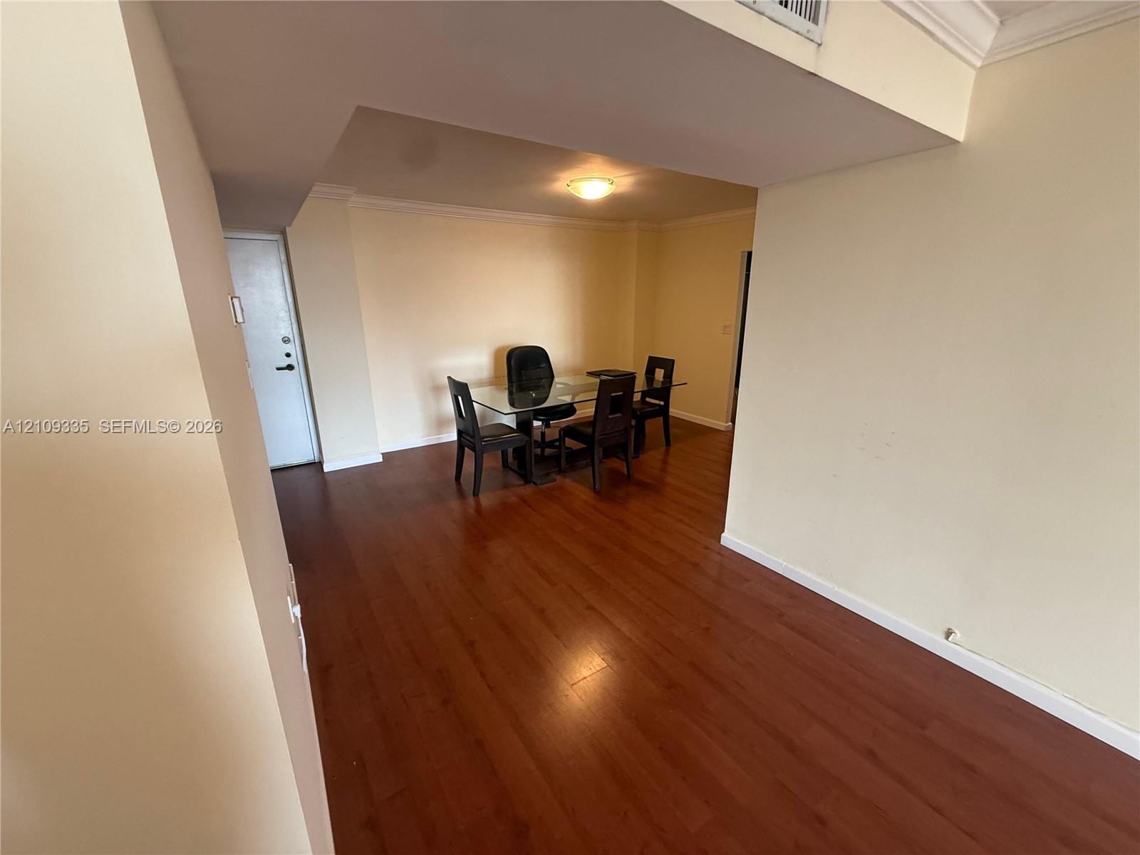 Open interior space featuring wood-finish flooring and crown molding Open interior space featuring wood-finish flooring and crown molding