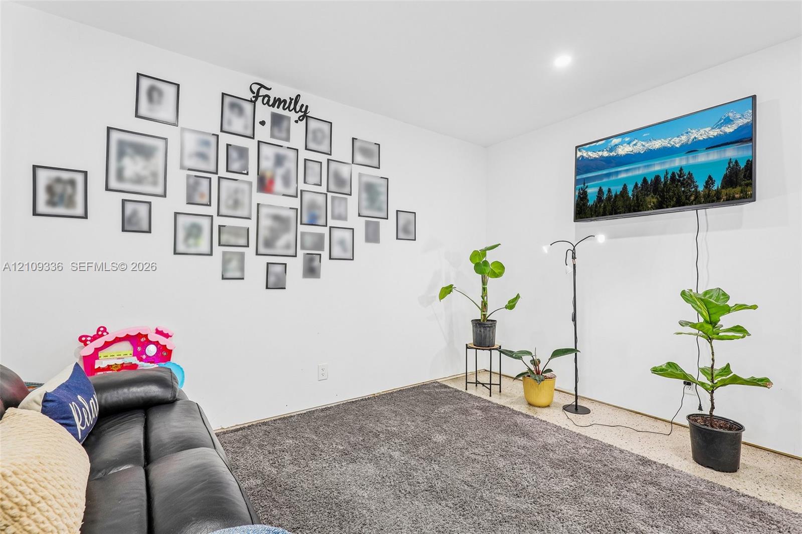 Neutral interior featuring crisp white walls, recessed ceiling lighting, and wall-mounted television hardware