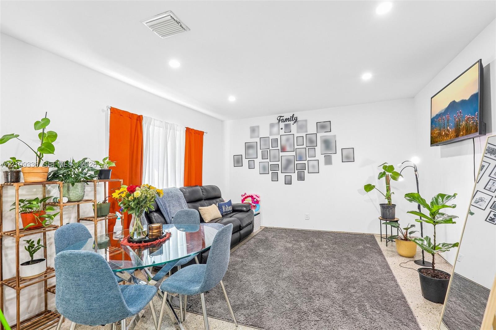 Open-concept living space featuring recessed lighting, smooth wall finishes, and stone-composite flooring