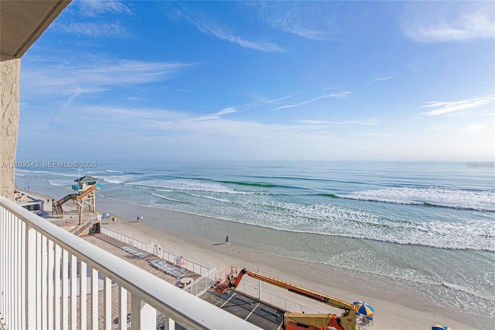 Private balcony with white vertical-bar railings overlooking the Atlantic Ocean coastline