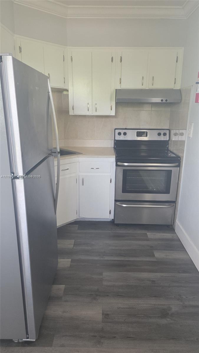Kitchen featuring white cabinetry, wood-finish flooring, stainless steel freestanding range, stainless steel refrigerator, and integrated range hood