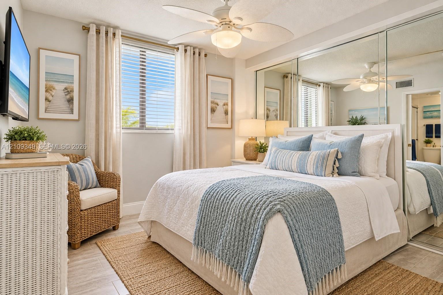 Bedroom featuring tile flooring, ceiling fan with integrated lighting, window with slatted blinds, and floor-to-ceiling mirrored wardrobe doors