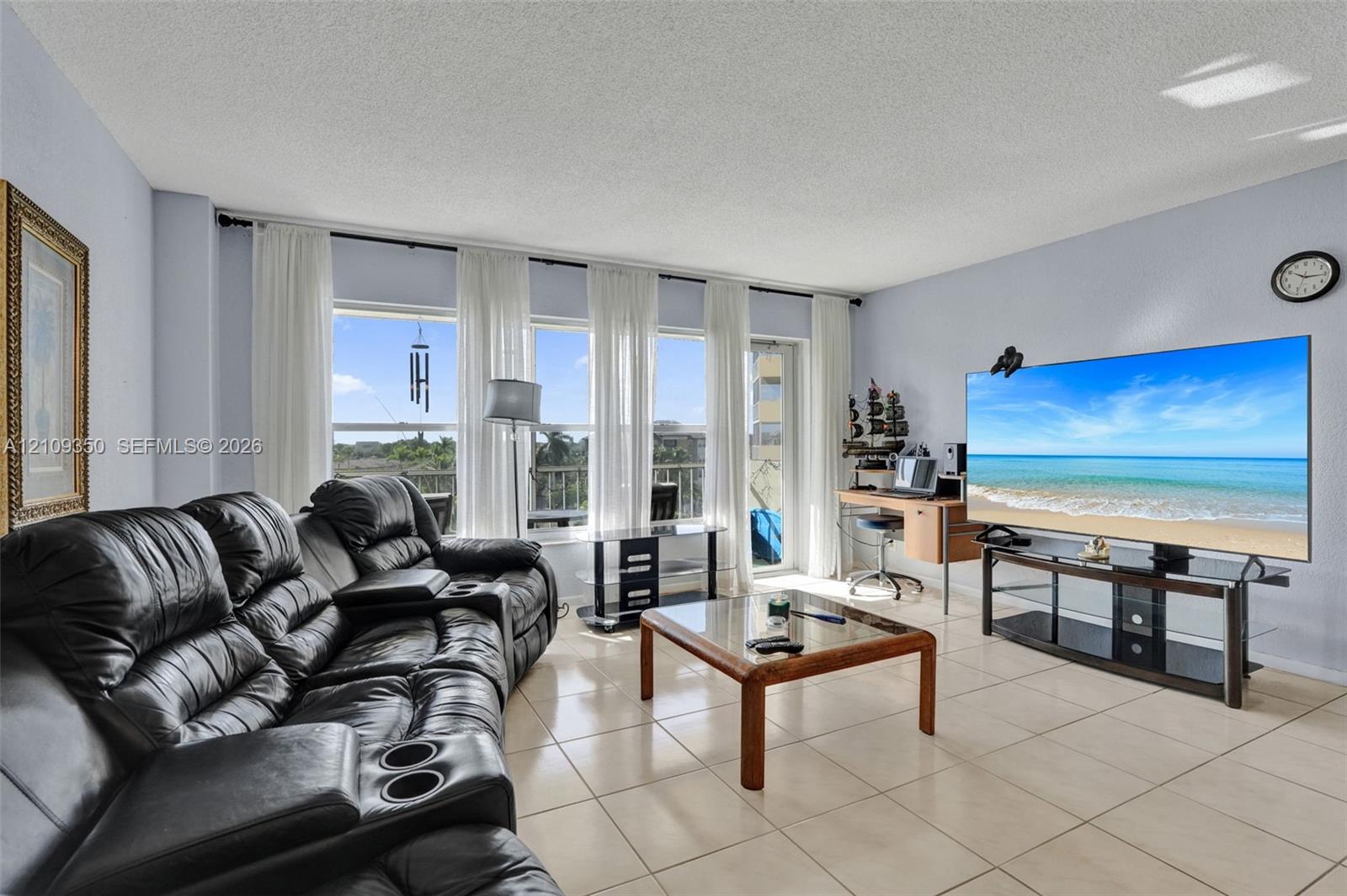 Living area featuring expansive windows, natural light, and tile flooring