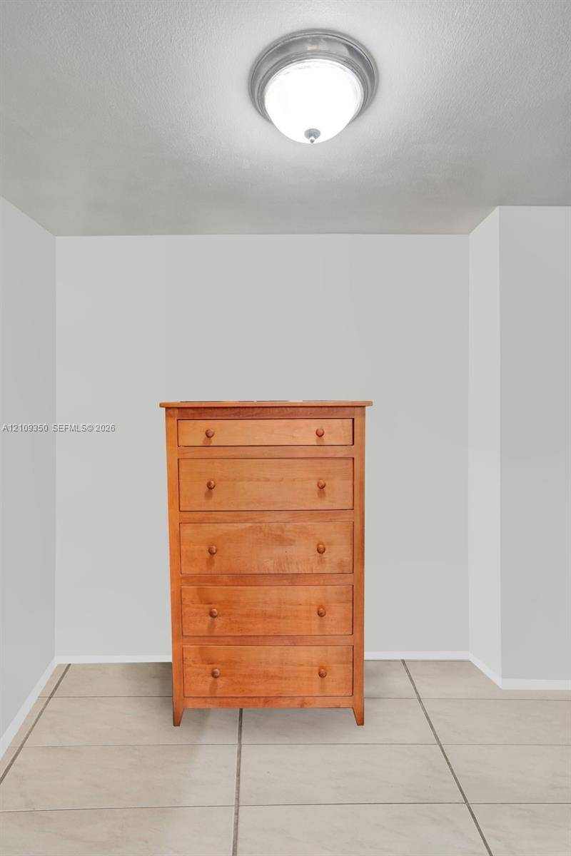 Neutral wall finishes, flush-mount circular ceiling lighting, and tile flooring