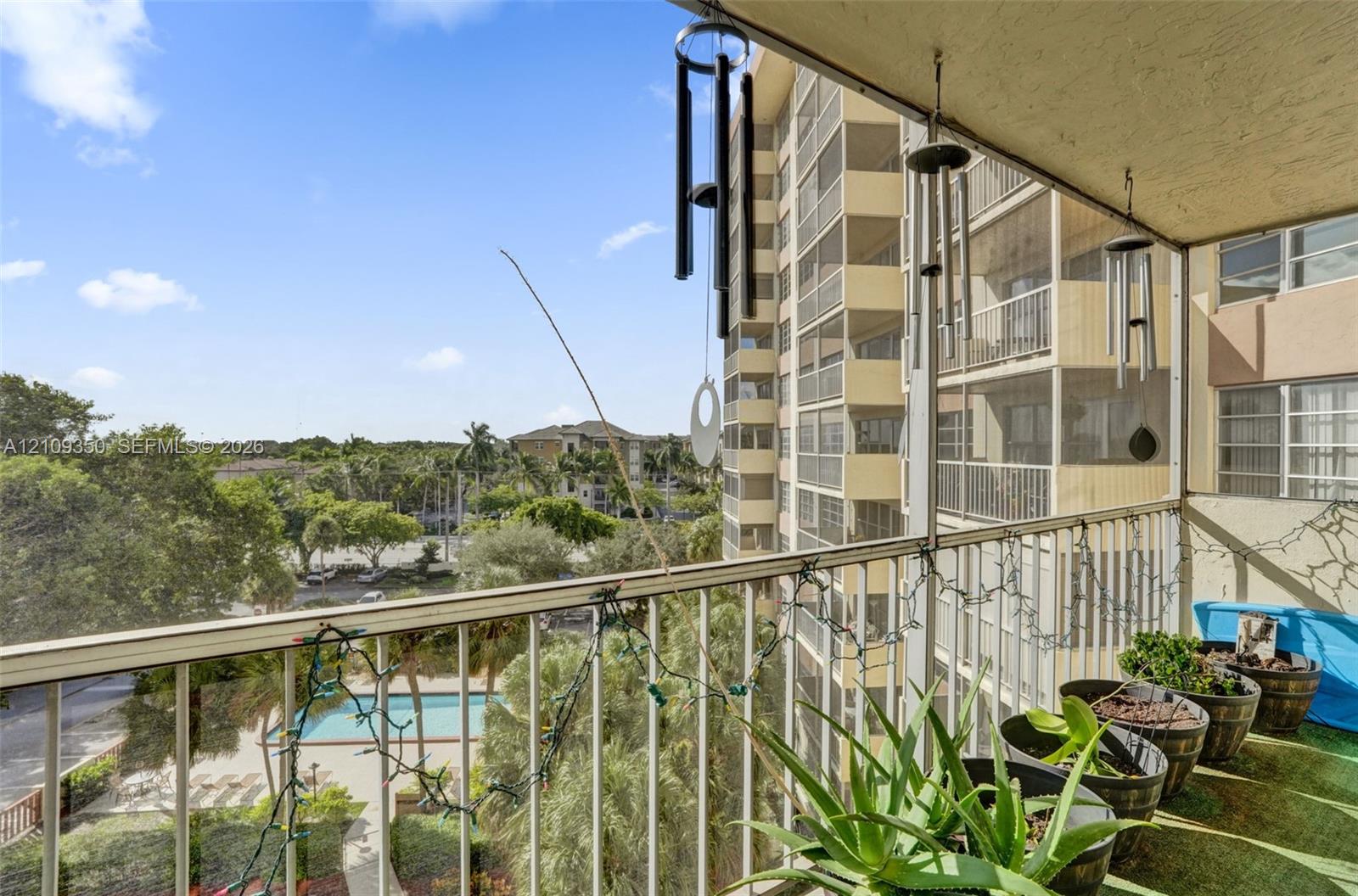 Covered balcony featuring metal railings and a screened-in exterior partition