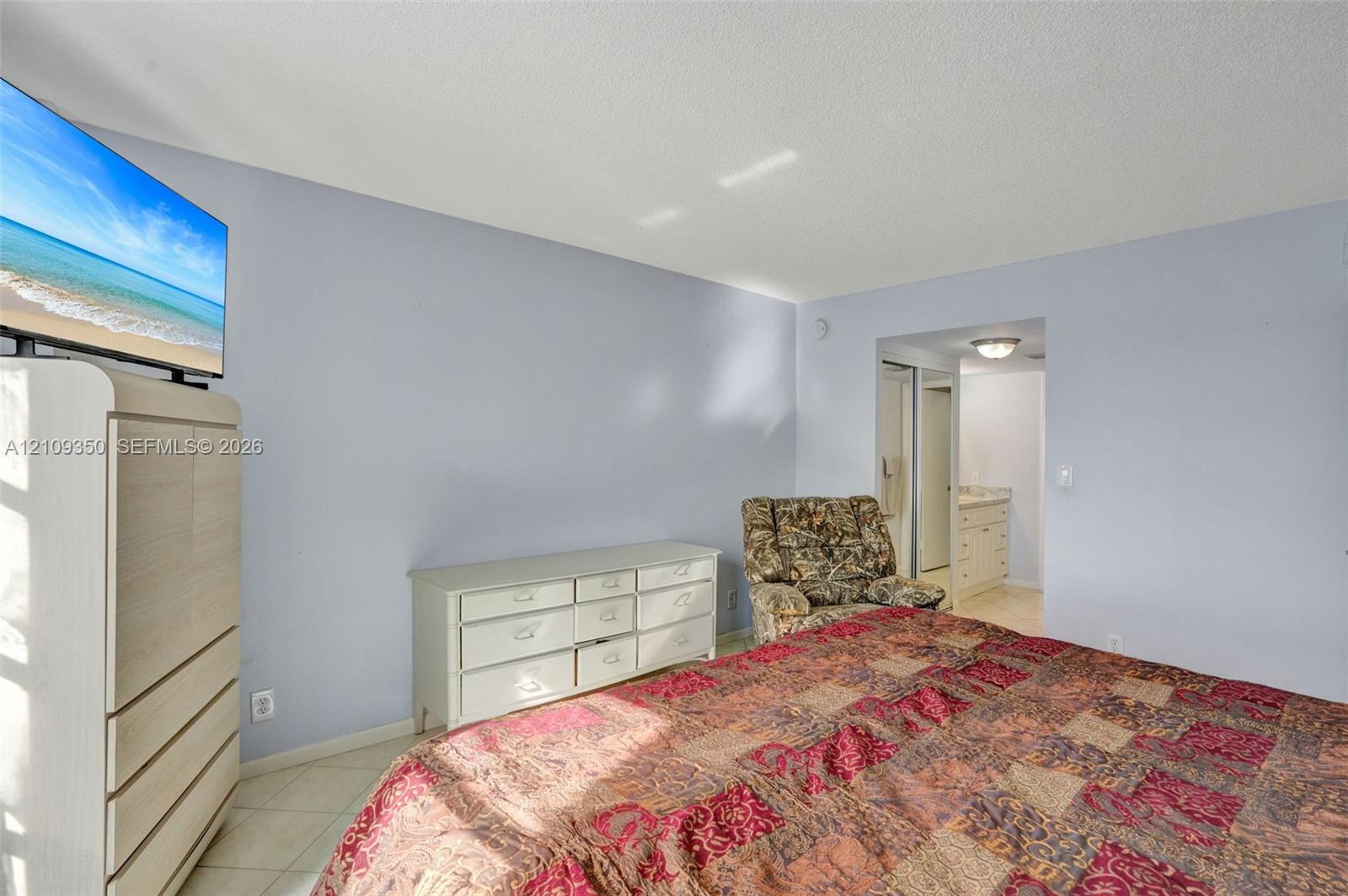 Neutral wall finishes, tile flooring, and a recessed doorway providing a glimpse into a secondary room with built-in cabinetry