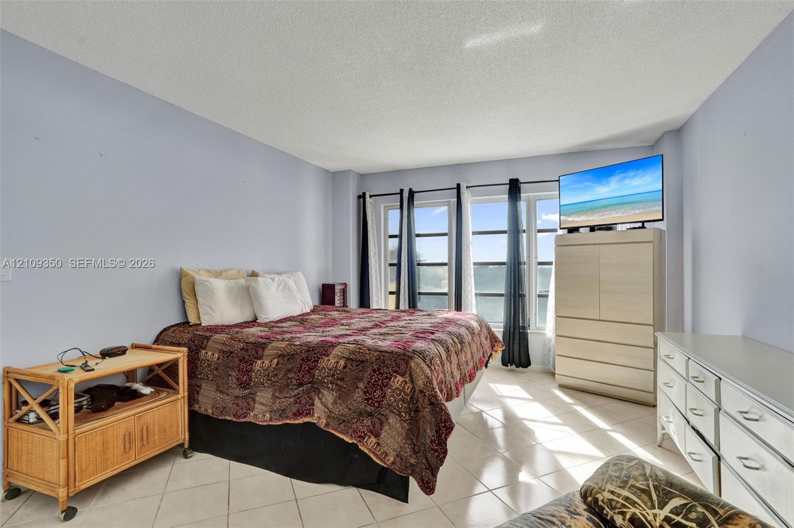 Spacious room featuring light-toned tile flooring and expansive multi-pane windows