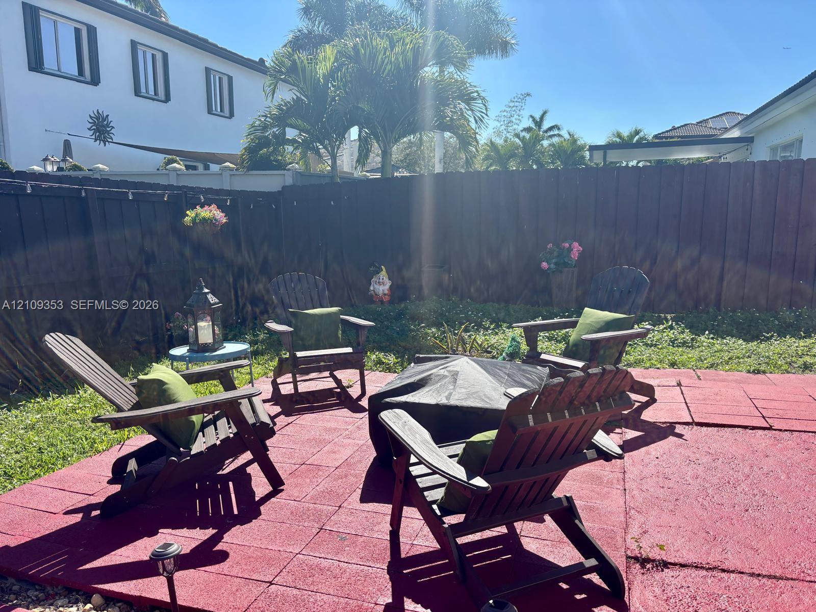 Rear exterior space featuring a paved patio area and a tall wood privacy fence
