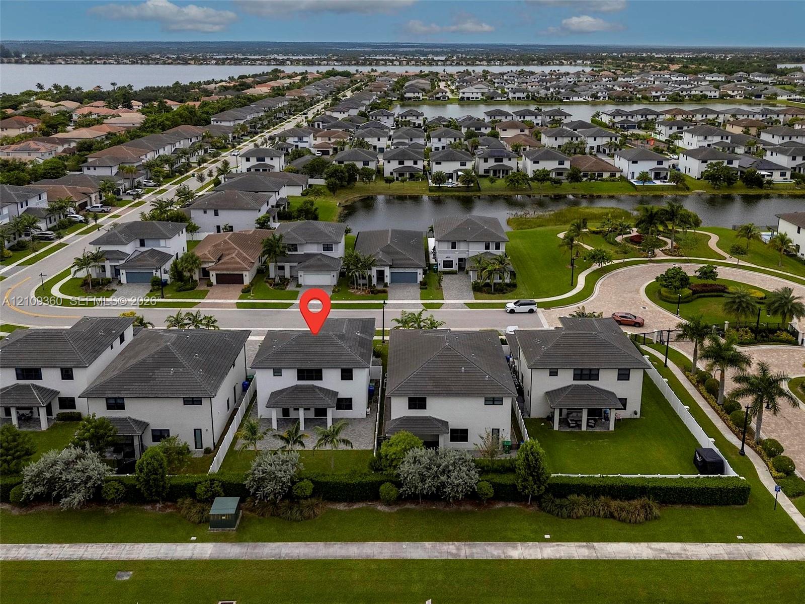 Two-story residence featuring a hipped roof, covered rear patio, integrated two-car garage, and a fenced backyard