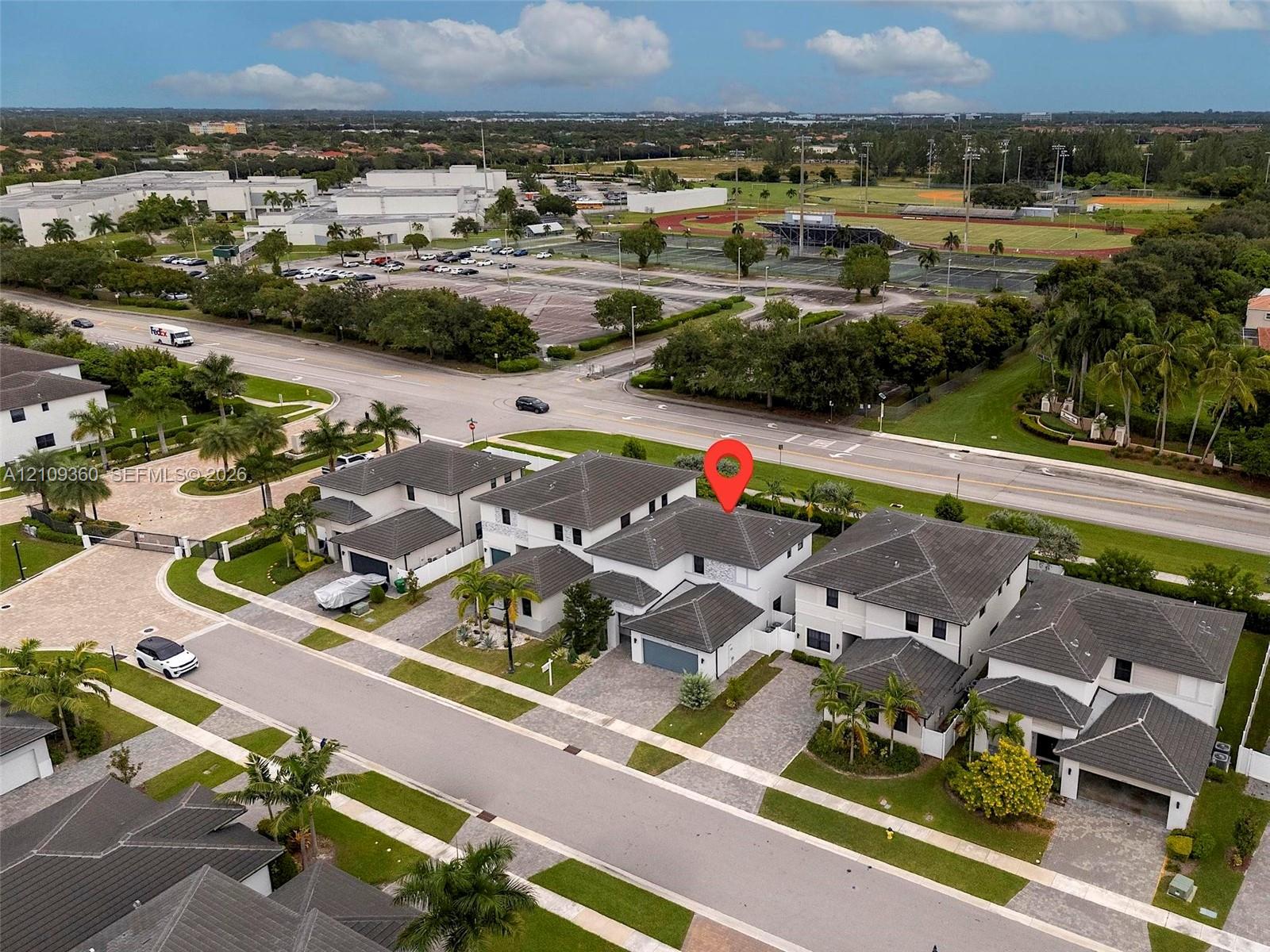 Multi-level residence featuring a concrete tile roof, light-toned exterior finish, and a paver driveway leading to a multi-car garage