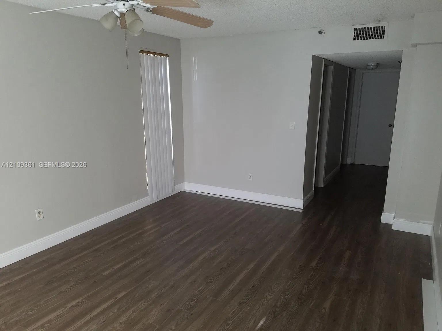 Wood-finish flooring, neutral wall tones, and ceiling fan with integrated lighting Wood-finish flooring, neutral wall tones, and ceiling fan with integrated lighting