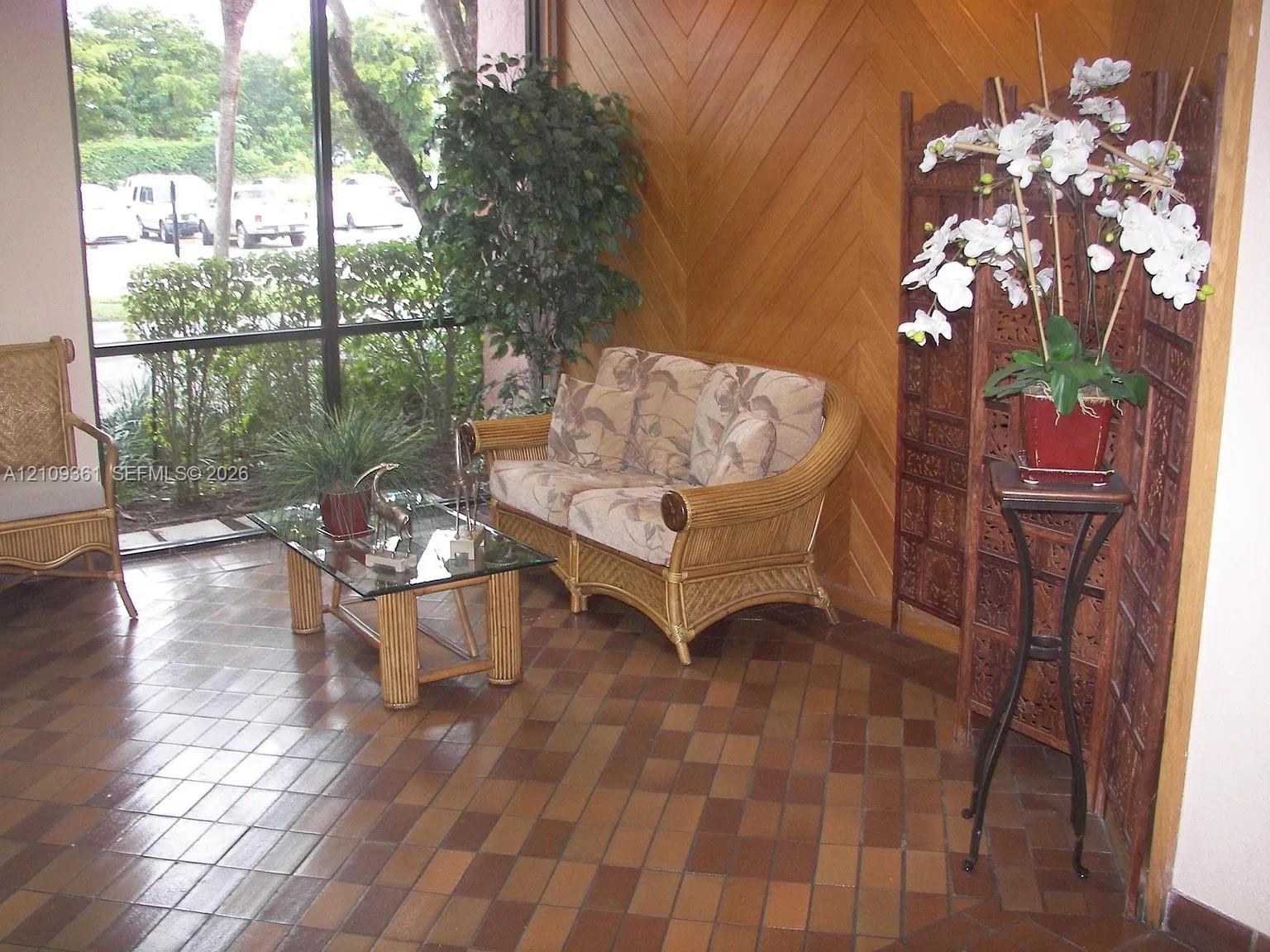 Floor-to-ceiling windows with dark metal framing, diagonal wood-paneled accent wall, and rectangular ceramic tile flooring