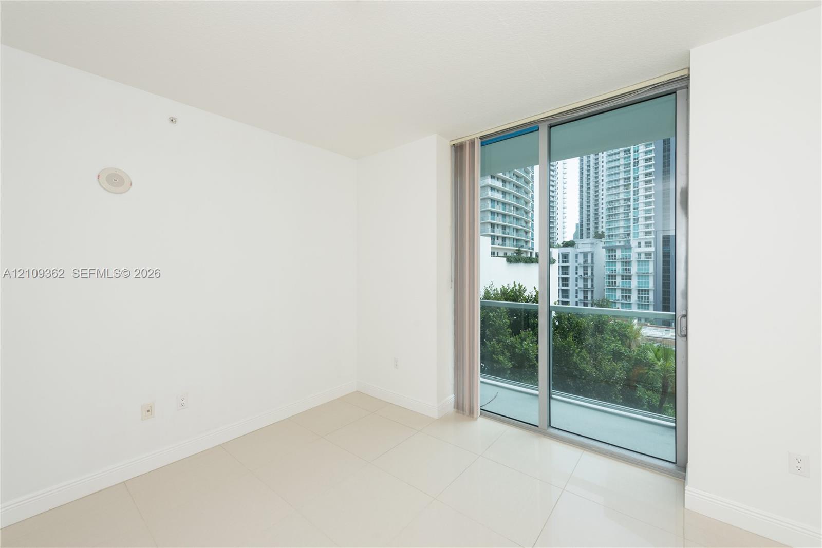 Floor-to-ceiling glass sliding door, porcelain tile flooring, and metallic frame balcony enclosure