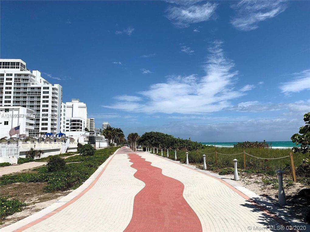 Paved pedestrian pathway featuring decorative red and white brick-style pavers and rope-style safety railing