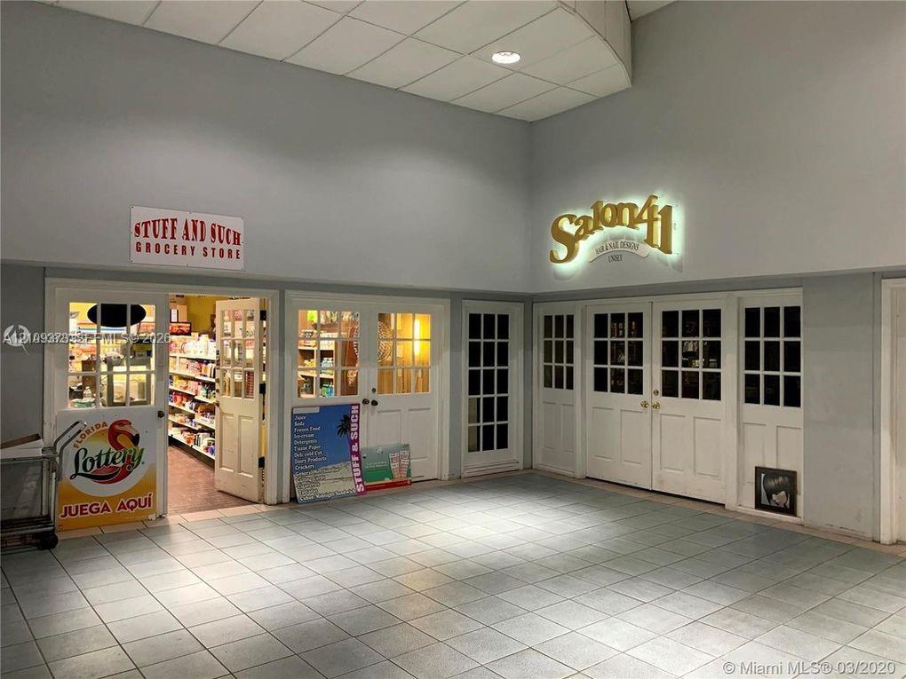 Commercial space featuring a large-format tiled floor, high ceilings, recessed lighting, and multiple divided-light glass panel doors