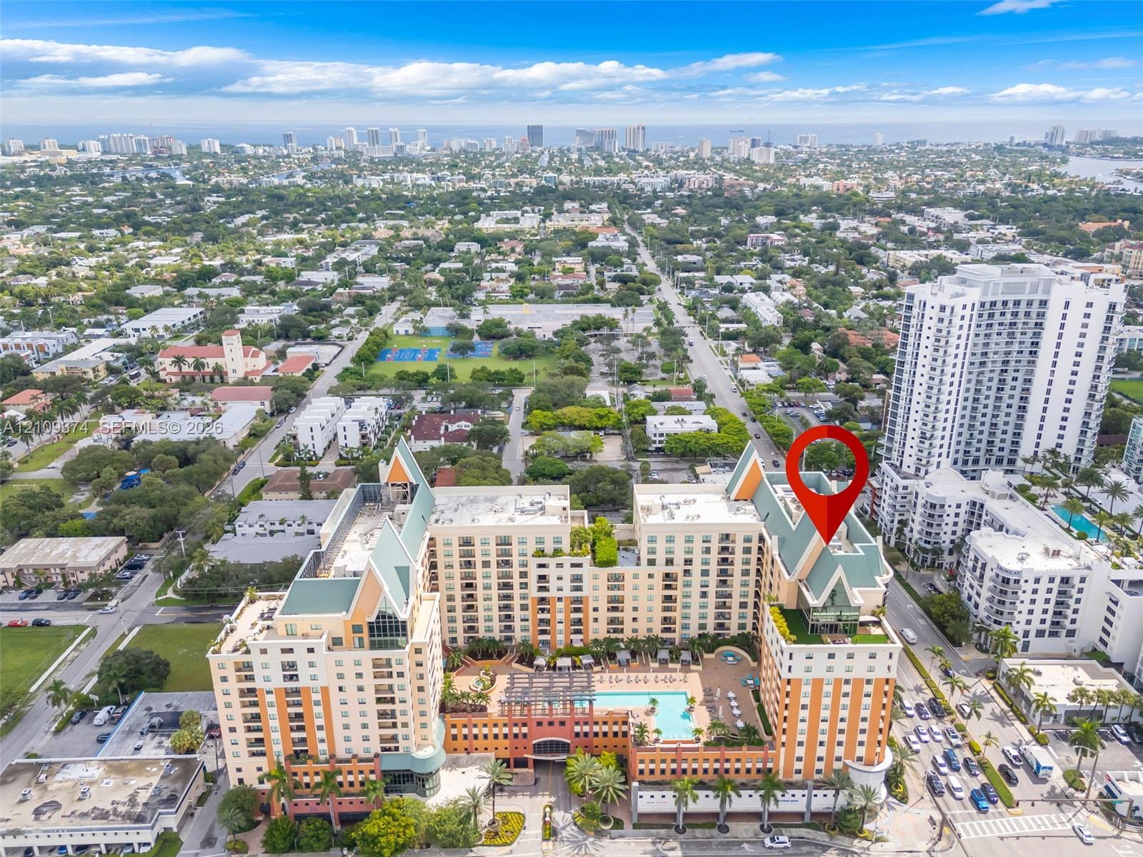 High-rise residential complex featuring a central courtyard swimming pool, multiple stepped balconies, steep pitched rooflines, and a structured exterior design High-rise residential complex featuring a central courtyard swimming pool, multiple stepped balconies, steep pitched rooflines, and a structured exterior design