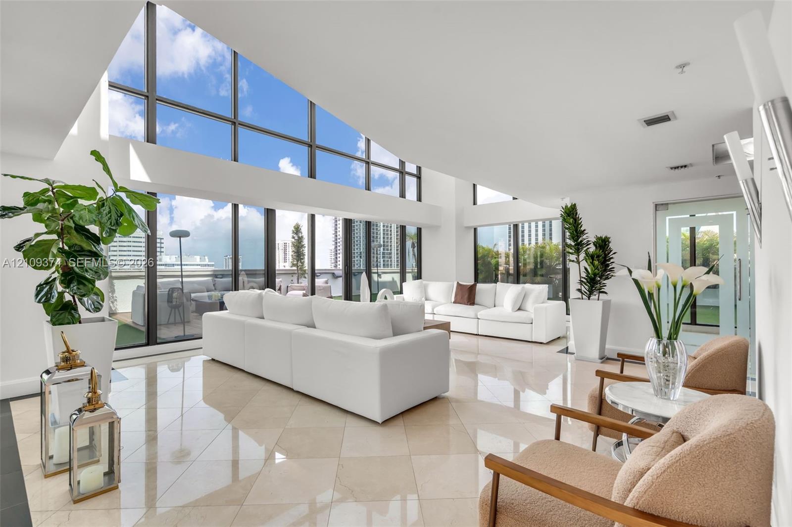 Vaulted ceilings featuring expansive floor-to-ceiling windows and polished stone tile flooring Vaulted ceilings featuring expansive floor-to-ceiling windows and polished stone tile flooring