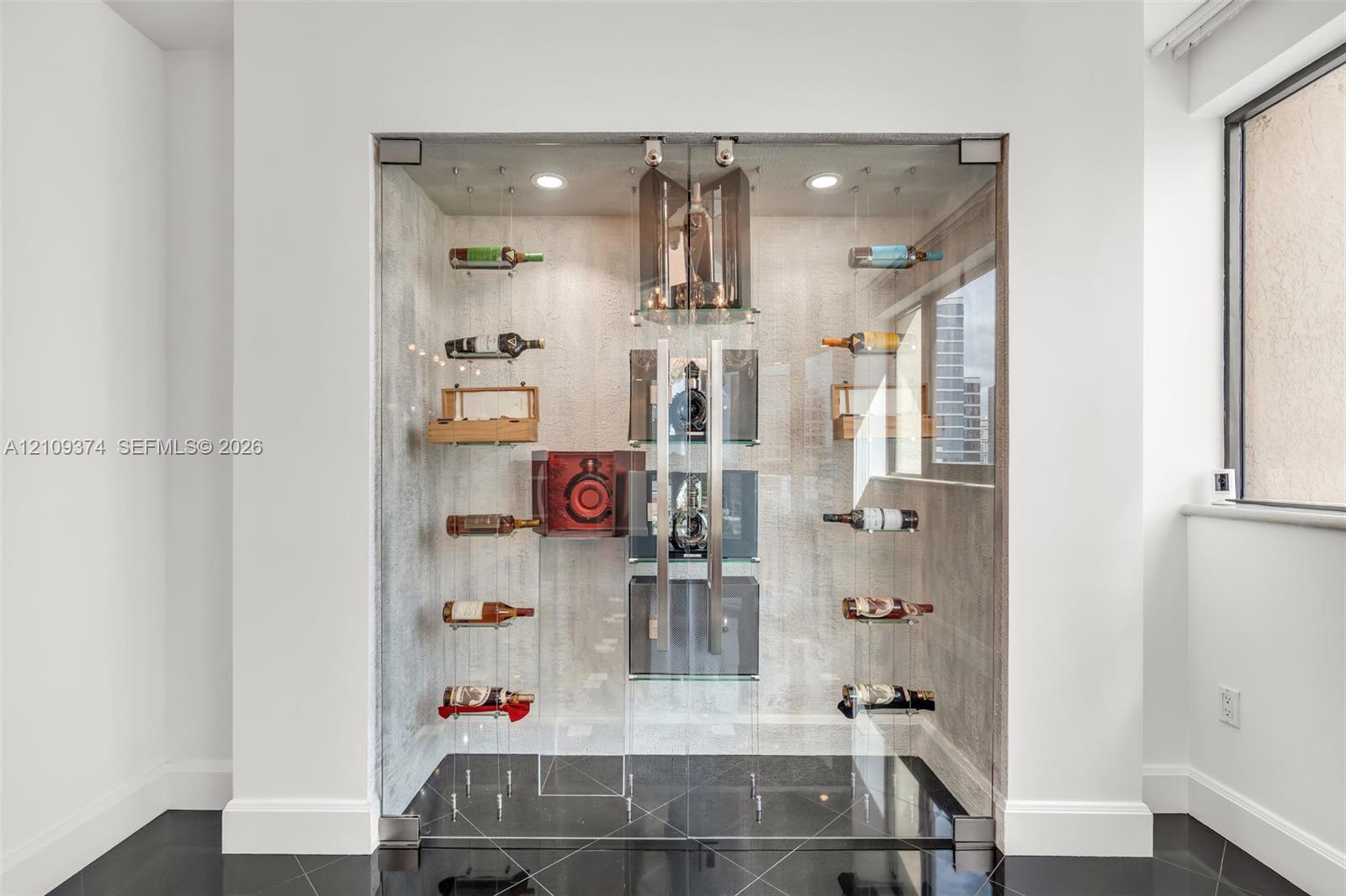 Custom climate-controlled display enclosure featuring floor-to-ceiling glass paneling, metal racking systems, integrated recessed lighting, and high-gloss tile flooring