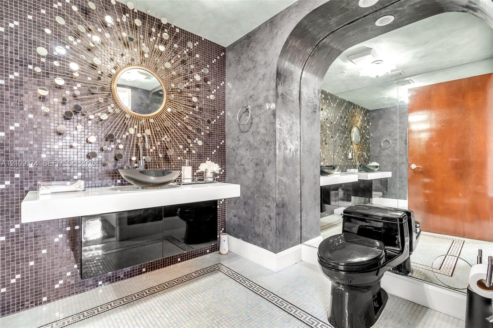 Floating vanity featuring a thick white countertop, integrated basin, and black high-gloss cabinetry