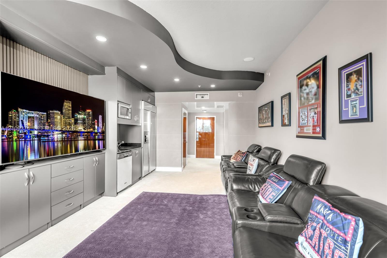 Custom built-in cabinetry with integrated microwave, stainless steel refrigerator, dishwasher, recessed ceiling lighting, and a distinctive curved architectural ceiling feature
