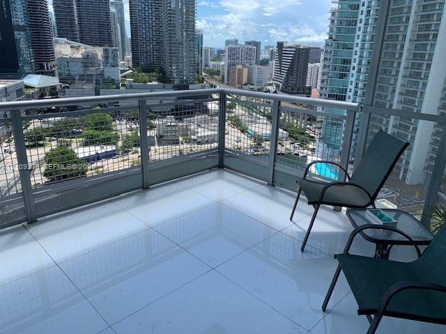 Private balcony featuring large-format ceramic tile flooring and metal railing with integrated wire mesh panels