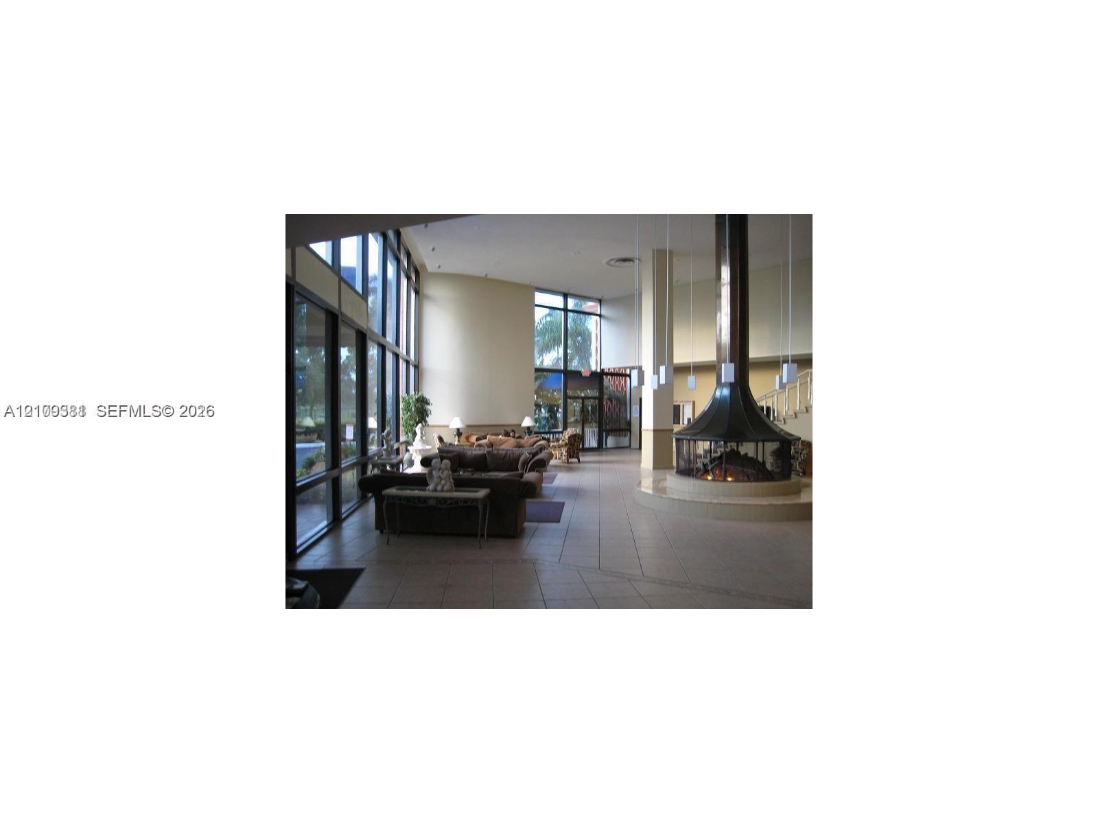 Floor-to-ceiling windows, circular suspended metal fireplace, tiled flooring, high ceilings, and recessed lighting