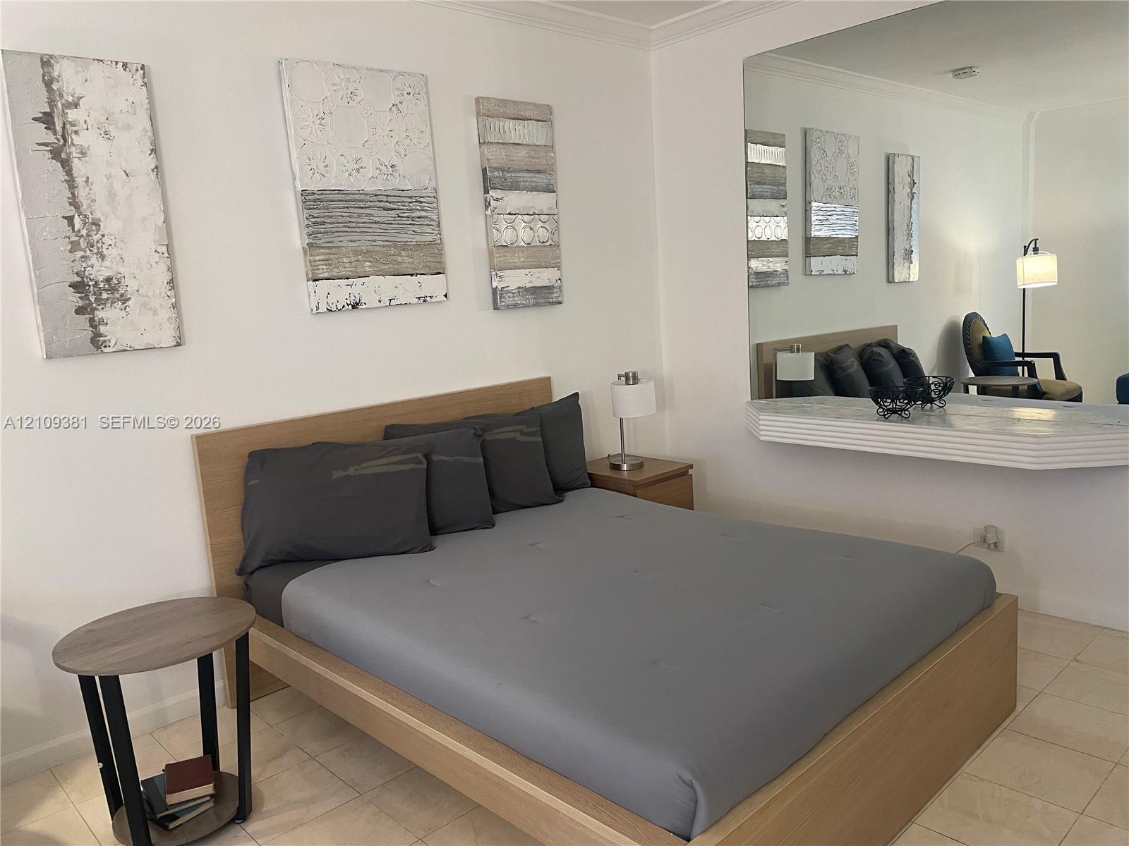 Large wall-mounted mirror featuring a wide, integrated shelf with a molded edge and tile flooring