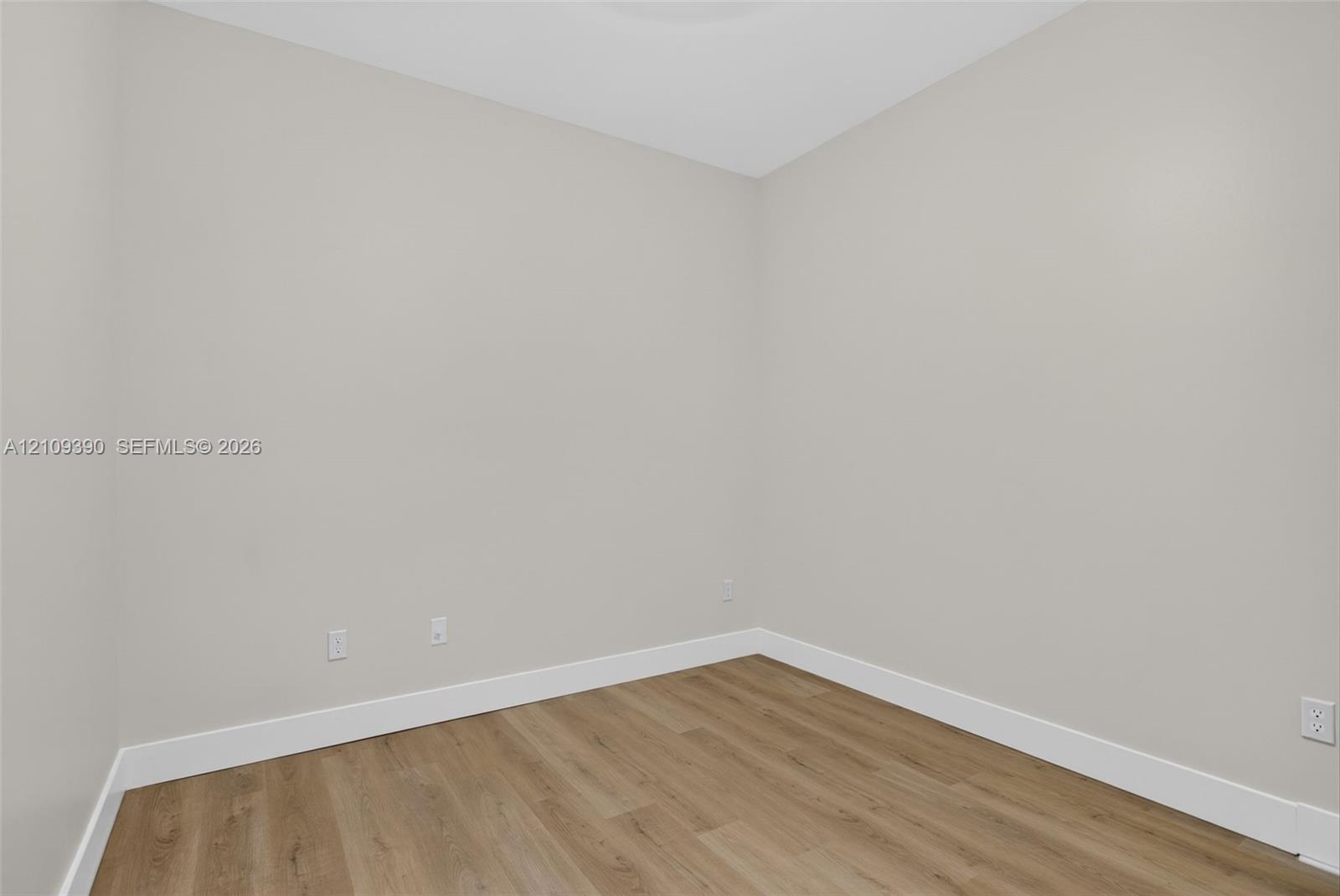 Neutral-toned wall finish, wood-finish flooring, and crisp white trim