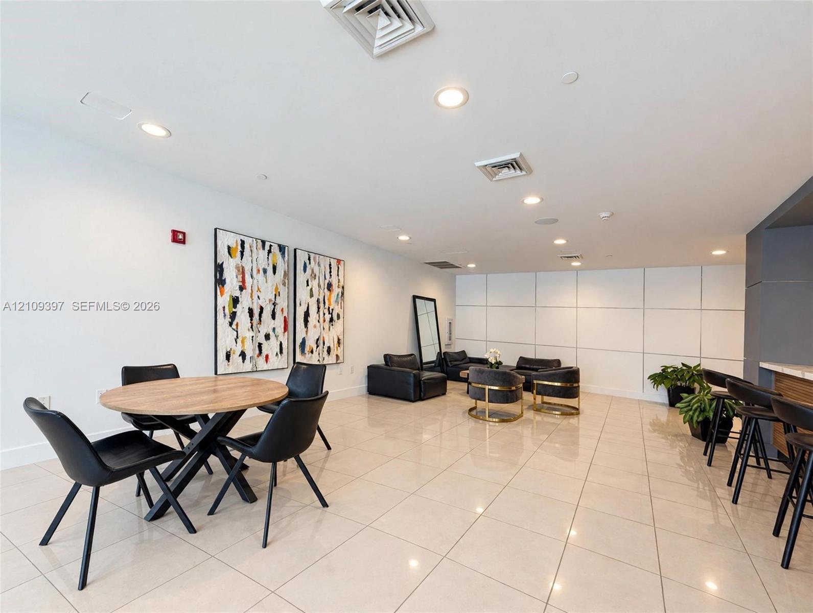Neutral-toned tile flooring, recessed ceiling lighting, and large-scale wall paneling