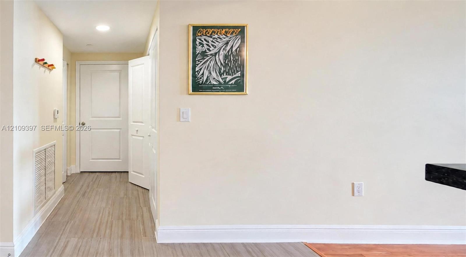 Neutral-toned interior featuring wood-finish flooring, recessed lighting, and white six-panel doors