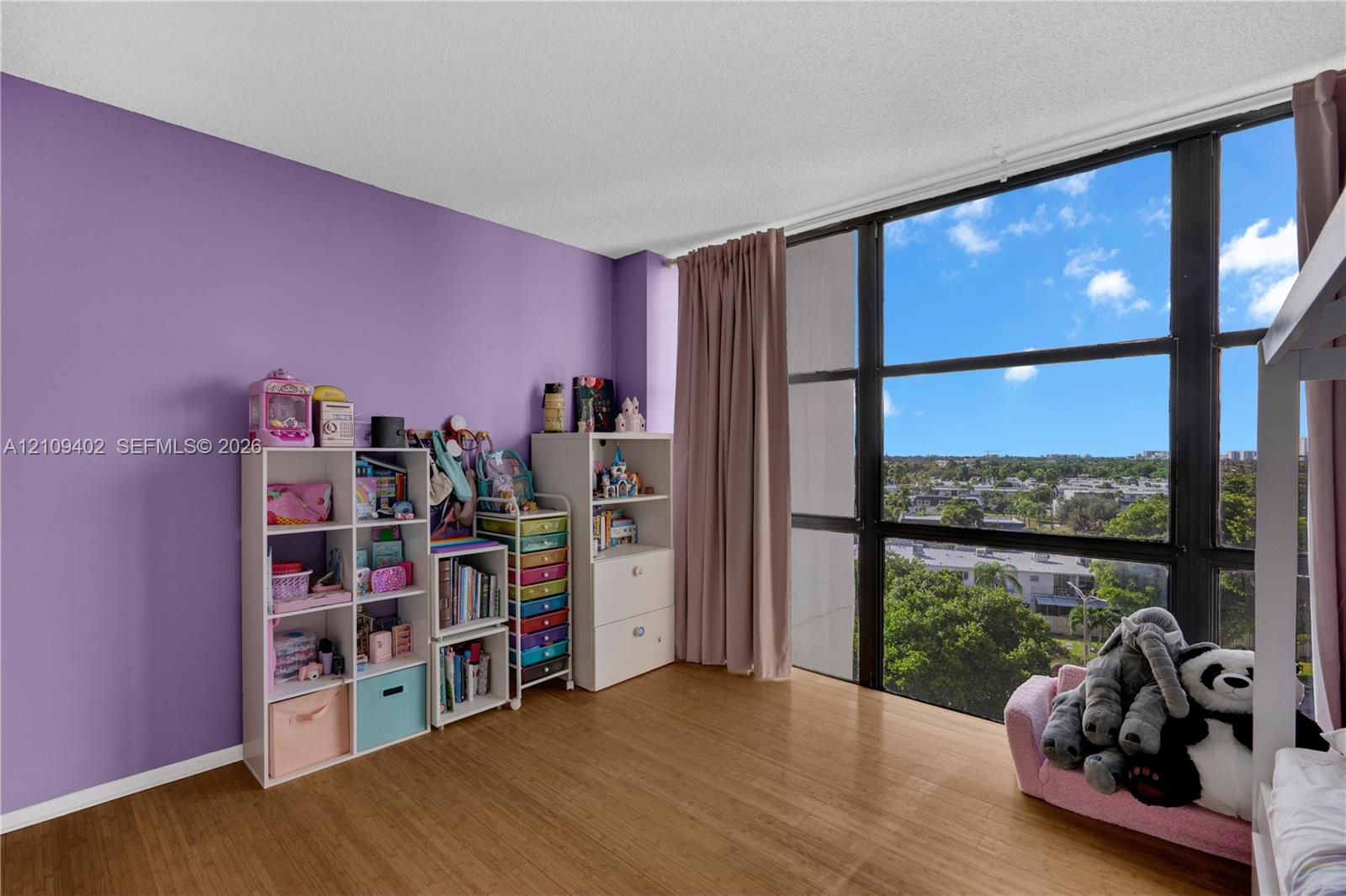 Floor-to-ceiling windows with black metal frames and wood-finish flooring