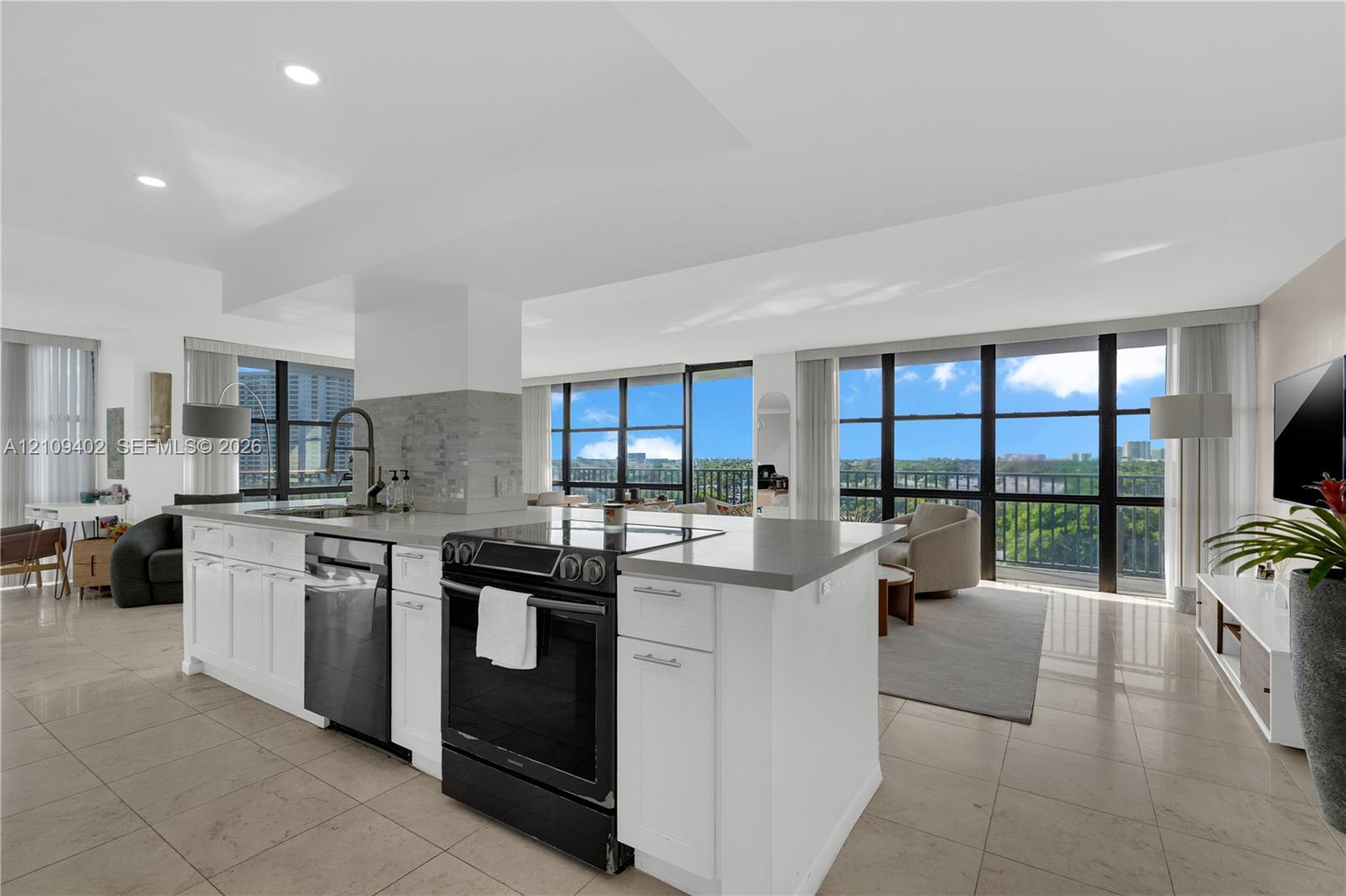 Kitchen featuring a center island with solid-surface countertops, floor-to-ceiling windows, recessed lighting, and large-format tile flooring