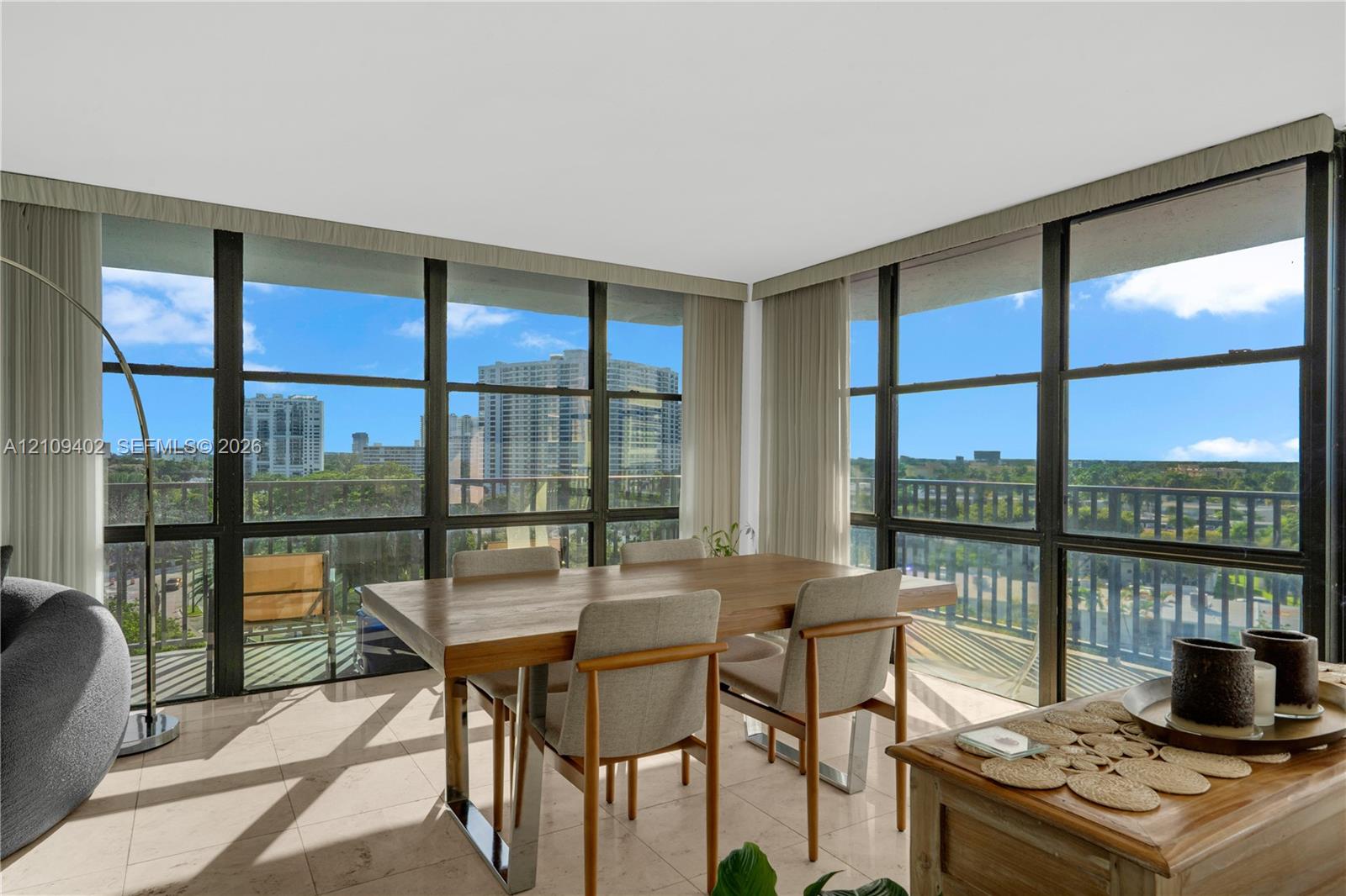 Floor-to-ceiling windows featuring black framing, polished stone flooring, and built-in window valances